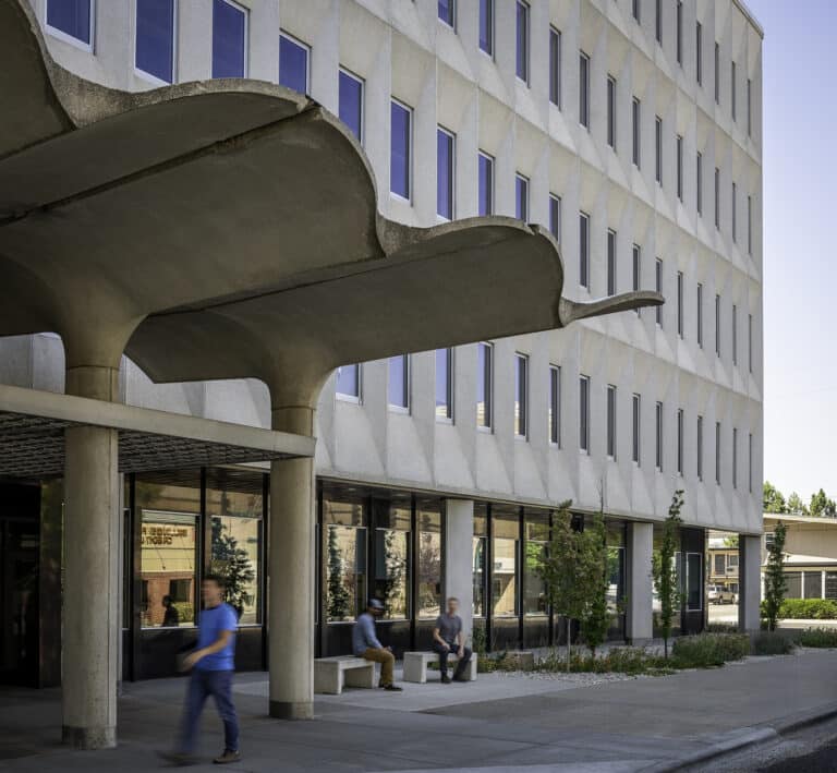 exterior view of white building with canopy at street-level